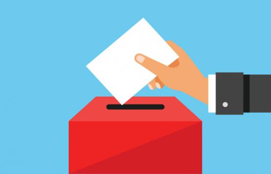 Imagen de mano depositando un voto en su urna
