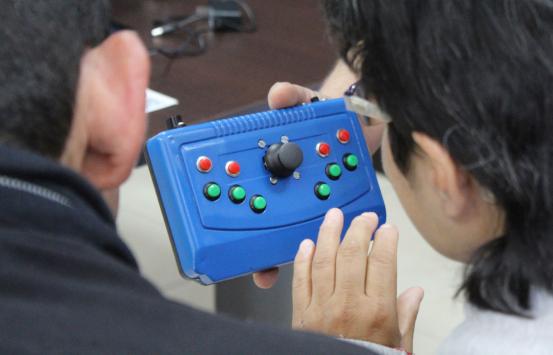 Fotografía, personas con discapacidad visual manipulando tecnologías en braille