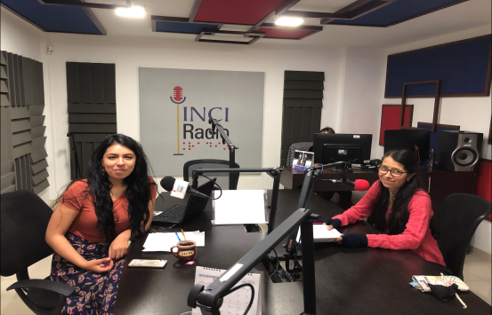 Libreta de Apuntes día mujer imagen de Nicole Cubillos y Gloria Peña en la cabina de INCIRadio, ellas sonríen frente al micrófono