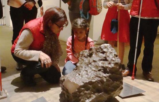 niña con discapacidad visual interactua con un meteoro en el Museo Nacional de Colombia