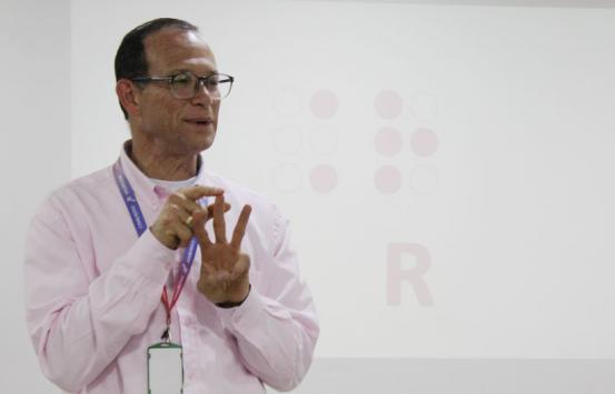 Enrique King, frente al auditorio dictando el taller de braille